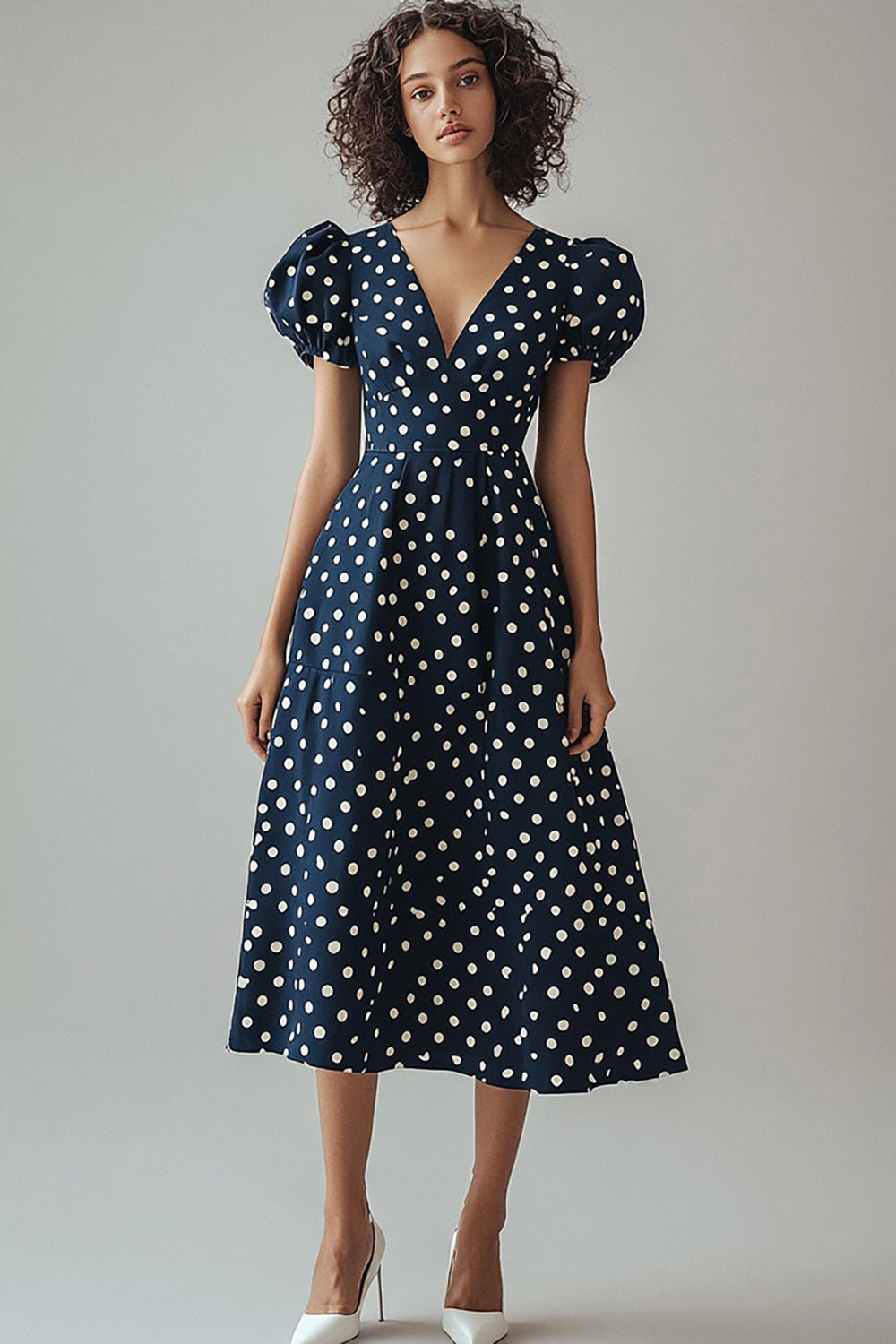 Une robe à pois blancs marine à col en V avec manches bouffantes