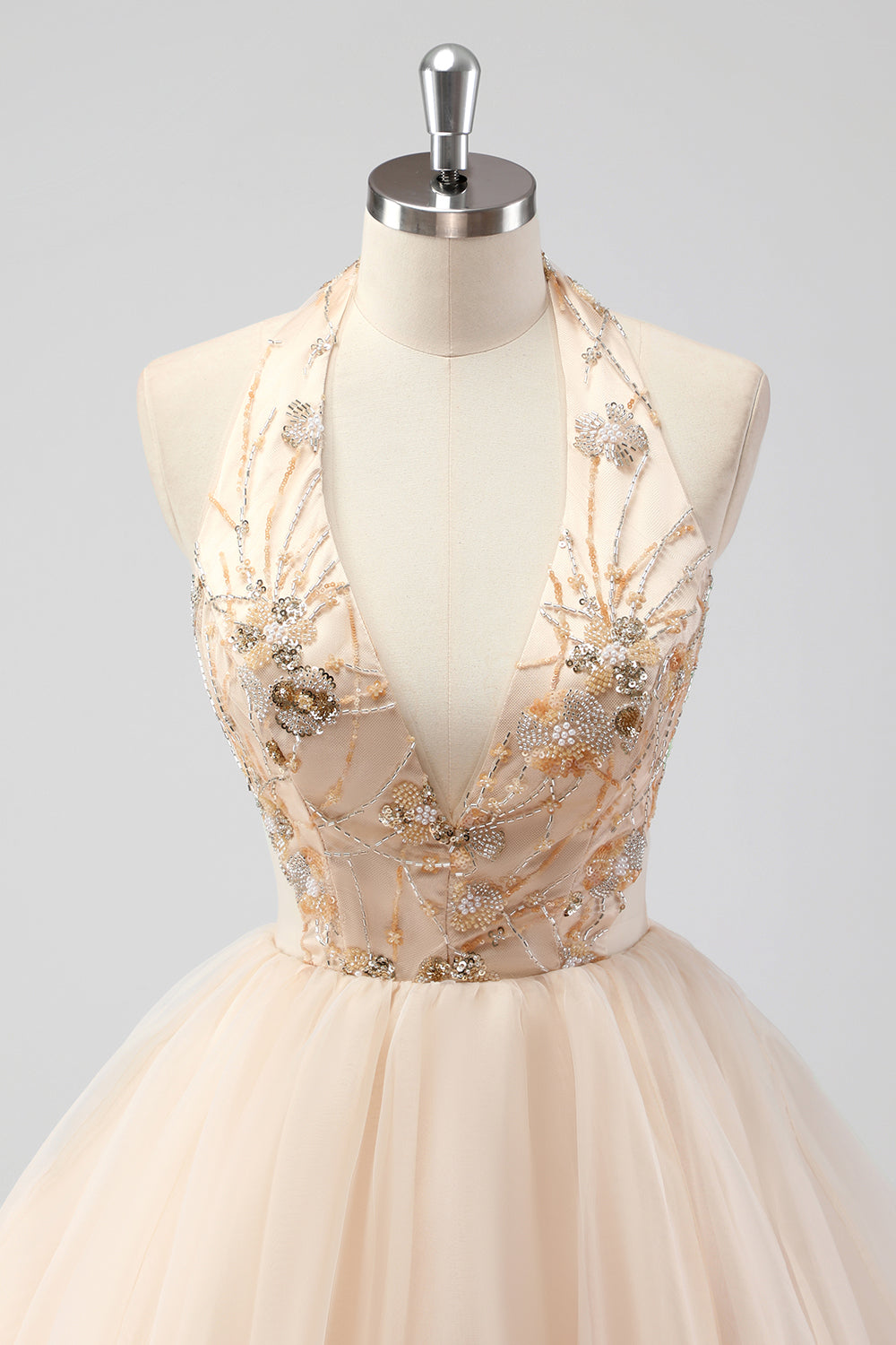 Une robe formelle à volants champagne perlée