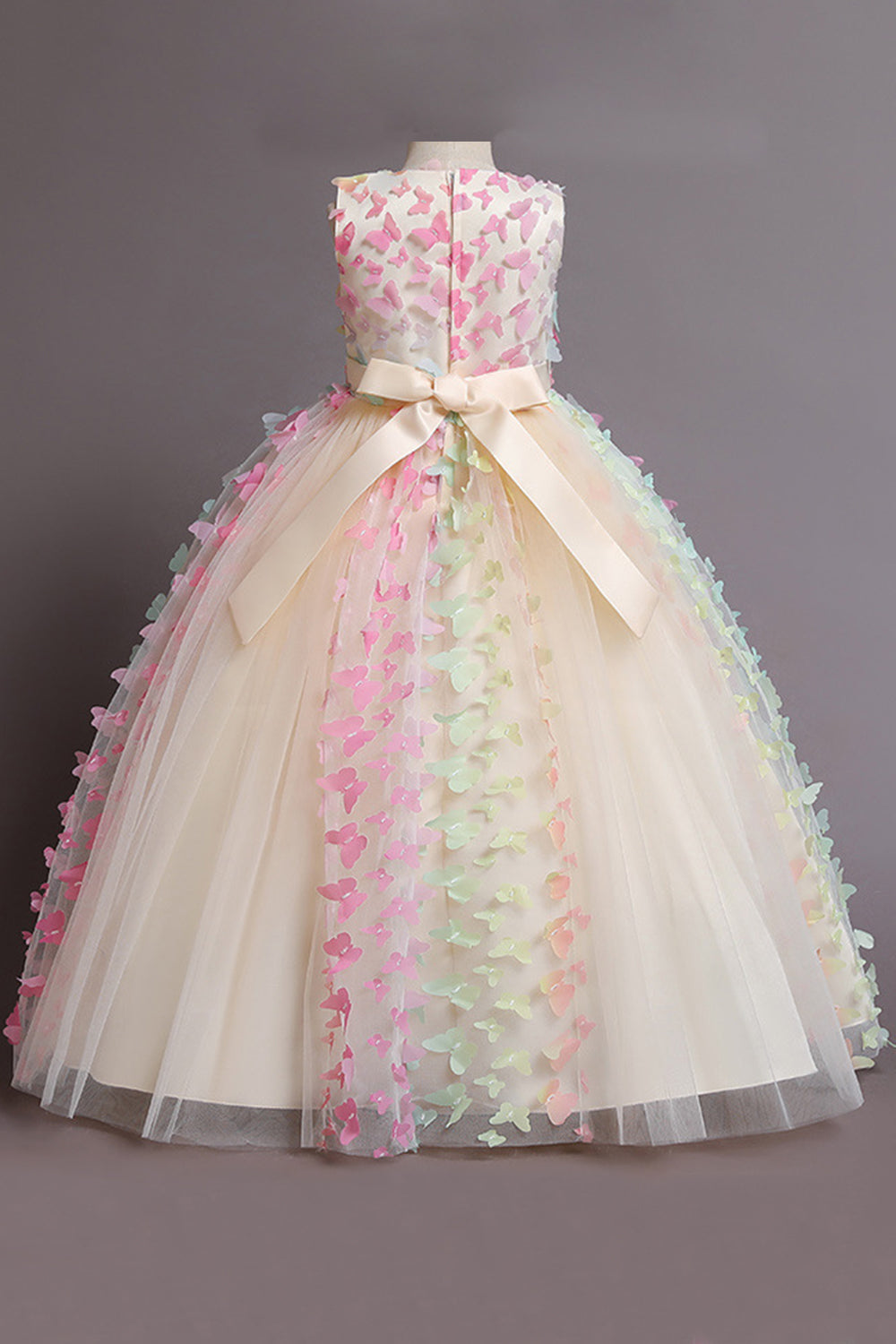 Une robe de fille beige sans manches avec des papillons