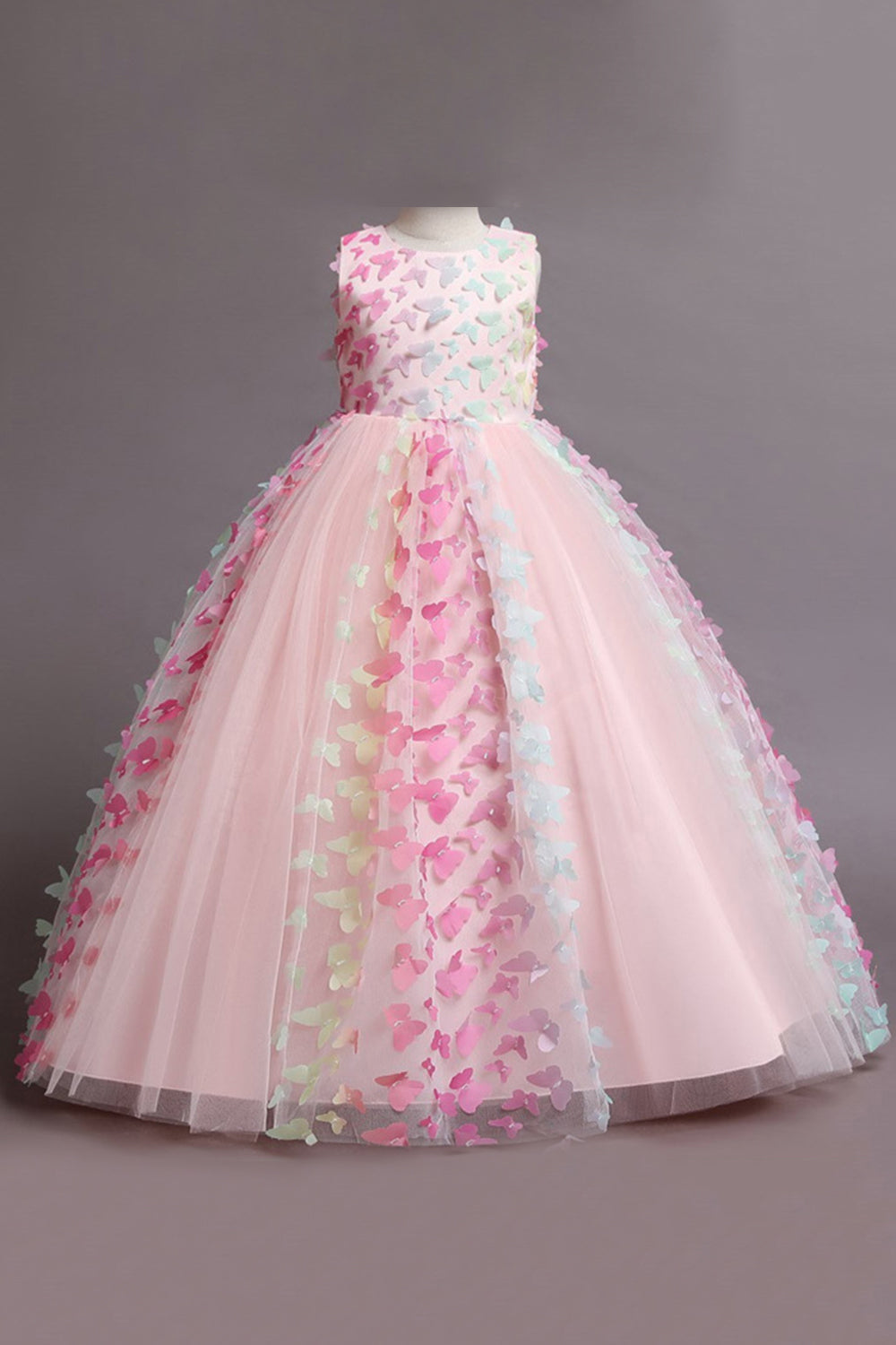 Une robe de fille beige sans manches avec des papillons