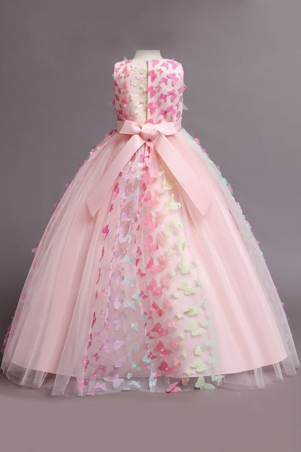 Une robe de fille beige sans manches avec des papillons