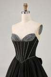 Robe de cocktail aux sources noire sans bretelles perlées avec noeud