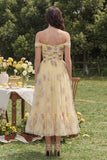 Robe midi en fleurs jaunes ligne en A décollée sur les épaules avec volants