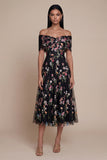 Une robe midi en tulle à l’épaule noire à applique dégagée
