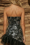 Robe cocktail courte noire, moulante et asymétrique, sans bretelles et perlée, avec volants