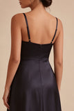 Une robe longue noire à bretelles fines avec poches