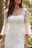 Longue robe de mariée en dentelle ivoire à manches 3/4 avec fente