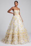 Robe de soirée longue jaune clair sans bretelles avec corset, volants, étages et appliqués floraux
