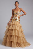 Robe de bal longue, en organza à volants dorée, sans bretelles et à volants