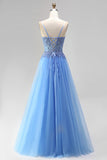 Robe de soirée longue bleue ligne A en tulle, à corset, appliqués perlés, fines bretelles et avec fente