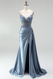 Robe de soirée gris bleu en satin avec un corset à strass, un effet de transparence et des fronces, à fines bretelles avec une fente