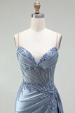 Robe de soirée gris bleu en satin avec un corset à strass, un effet de transparence et des fronces, à fines bretelles avec une fente
